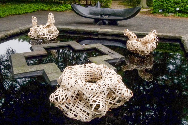 A woven flat reed floating installation titled Echo by Stephen Talasnik, at LongHouse Reserve, East Hampton, NY.
